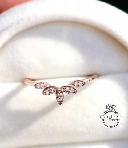 A close-up image of a delicate gold ring with a floral design, featuring small diamonds set in the center.