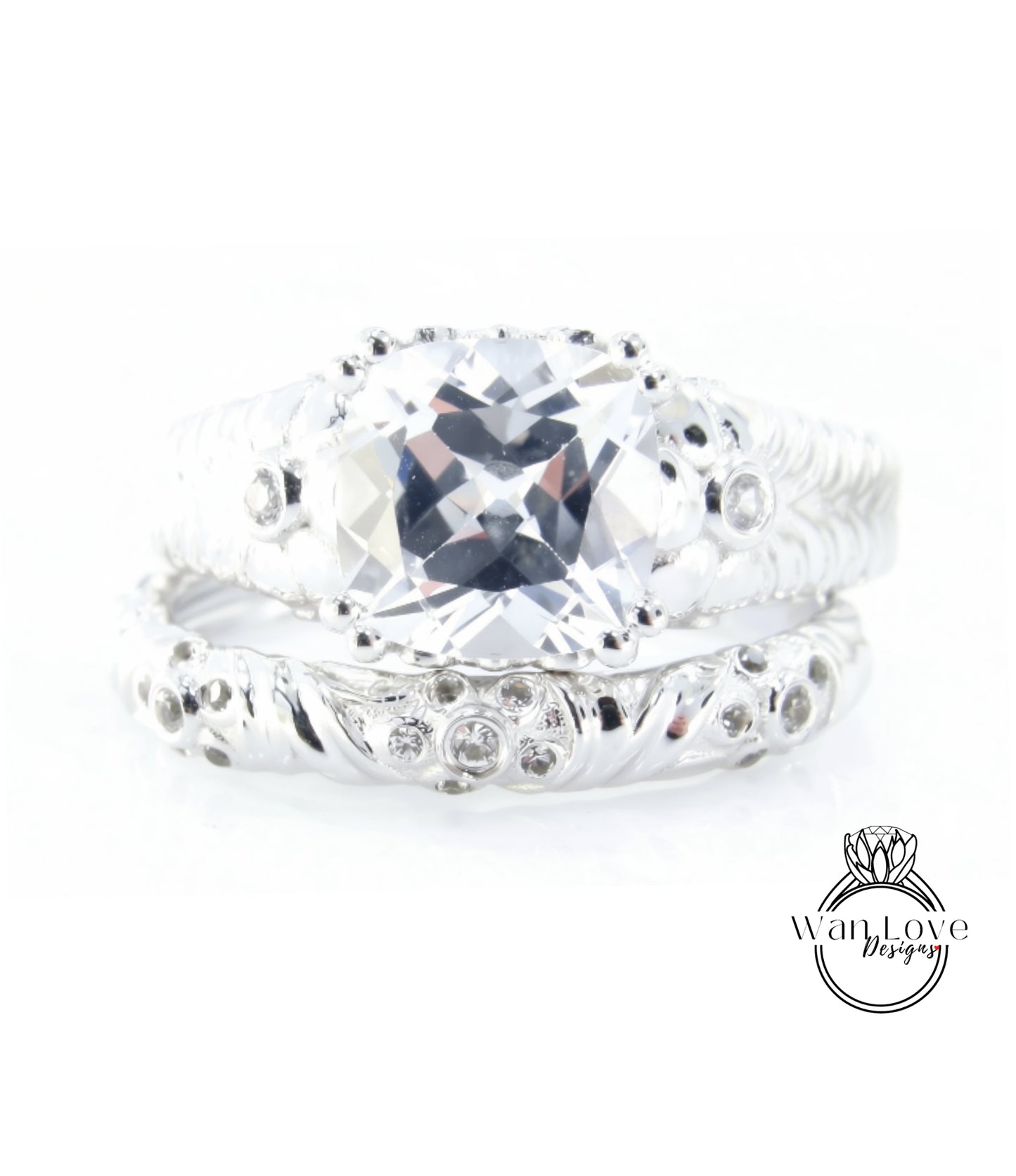 A close-up image of a silver ring with a large, clear gemstone set in the center.