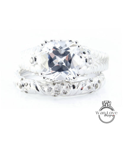 A close-up image of a silver ring with a large, clear gemstone set in the center.