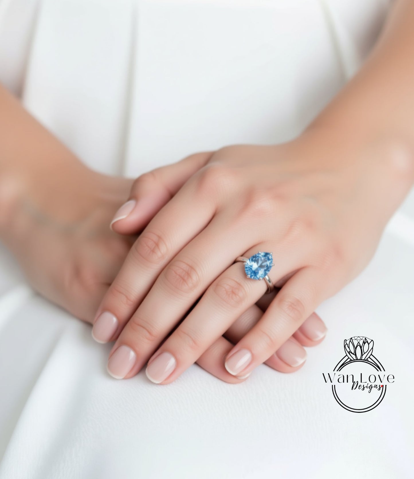 A close-up image of a person's hands wearing a ring with a blue gemstone.