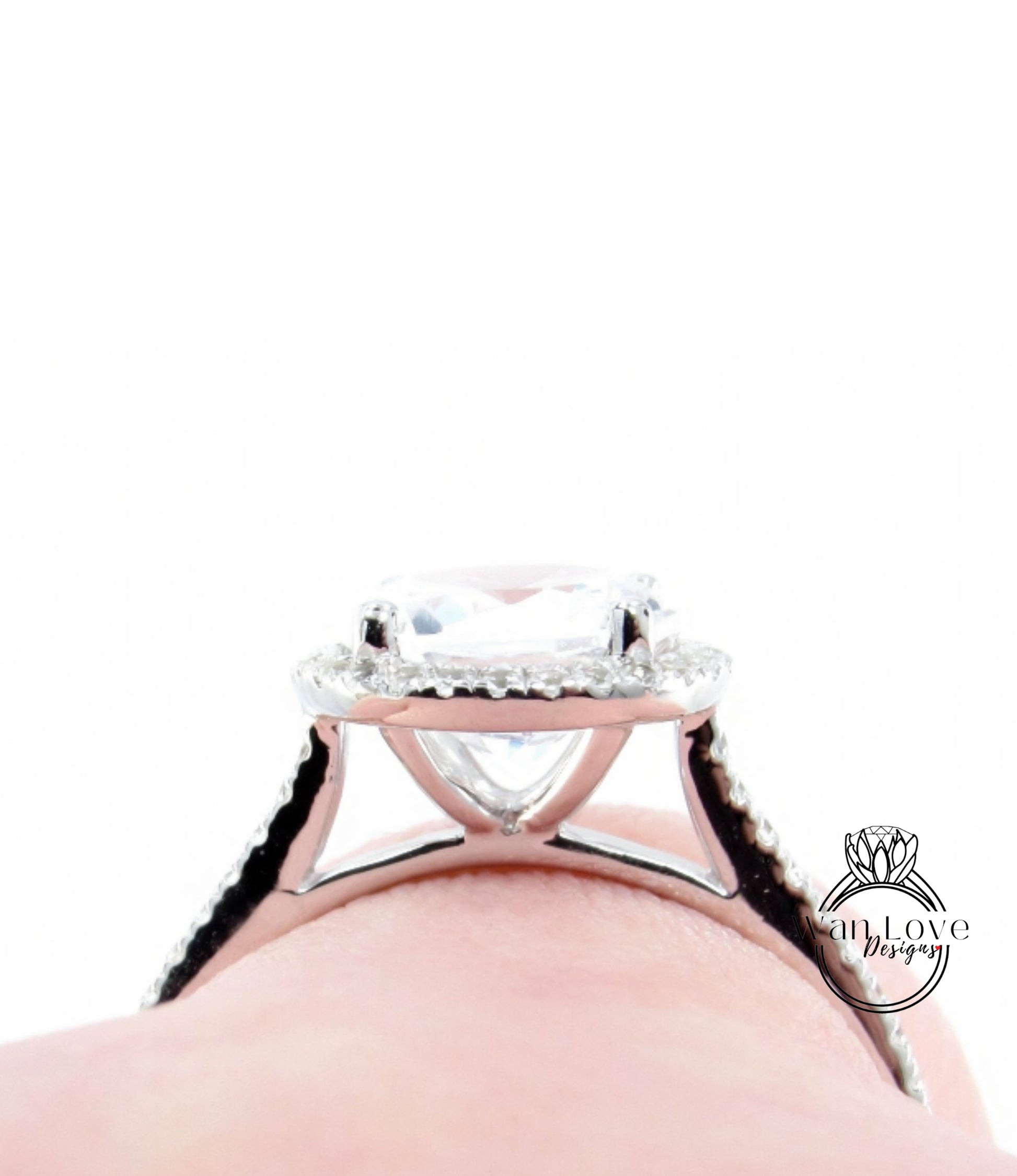 A close-up view of a diamond engagement ring on a person's hand, showcasing the intricate design and sparkling gemstone.