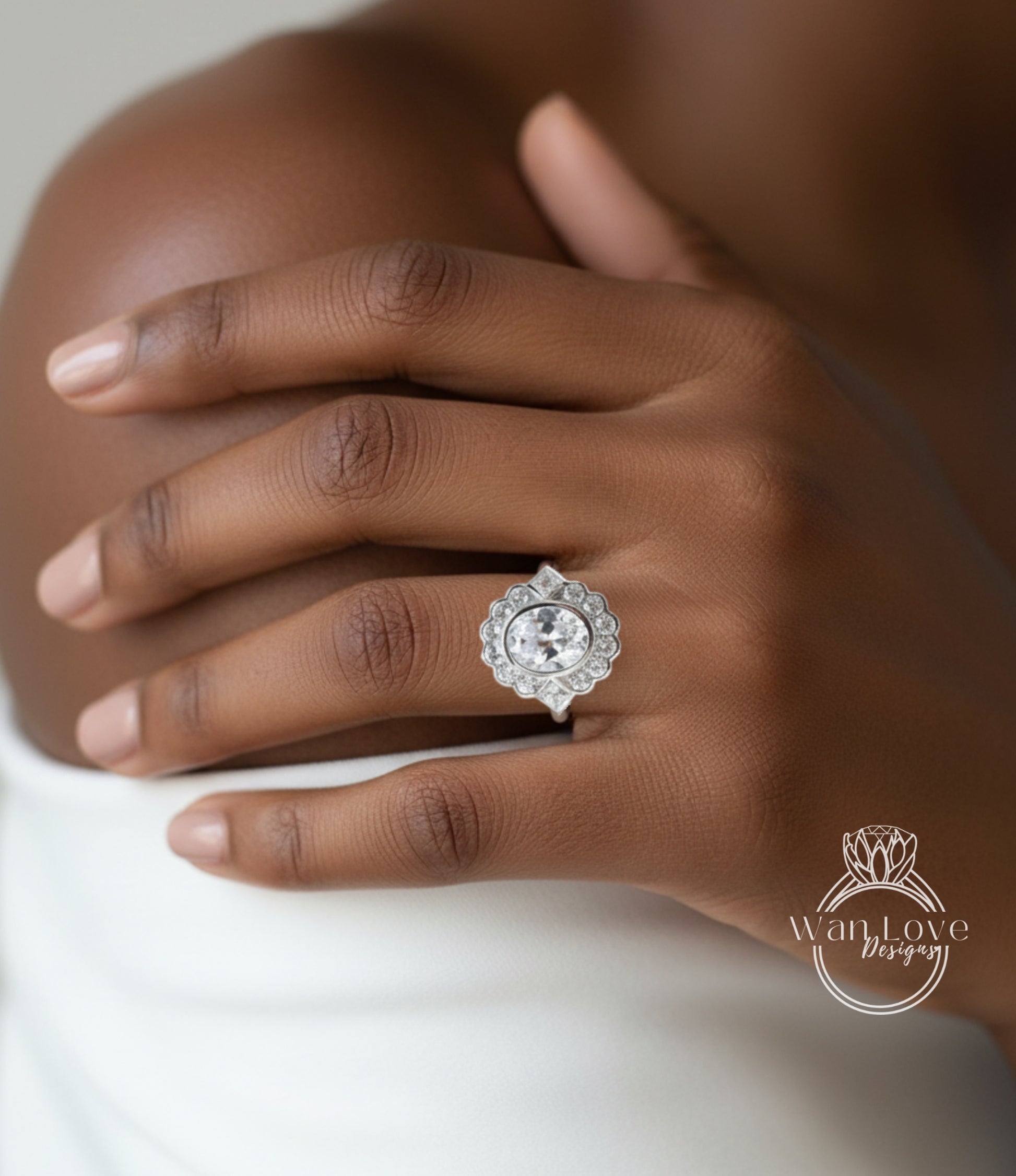 A close-up of a person's hand wearing a large, ornate diamond ring on the ring finger.