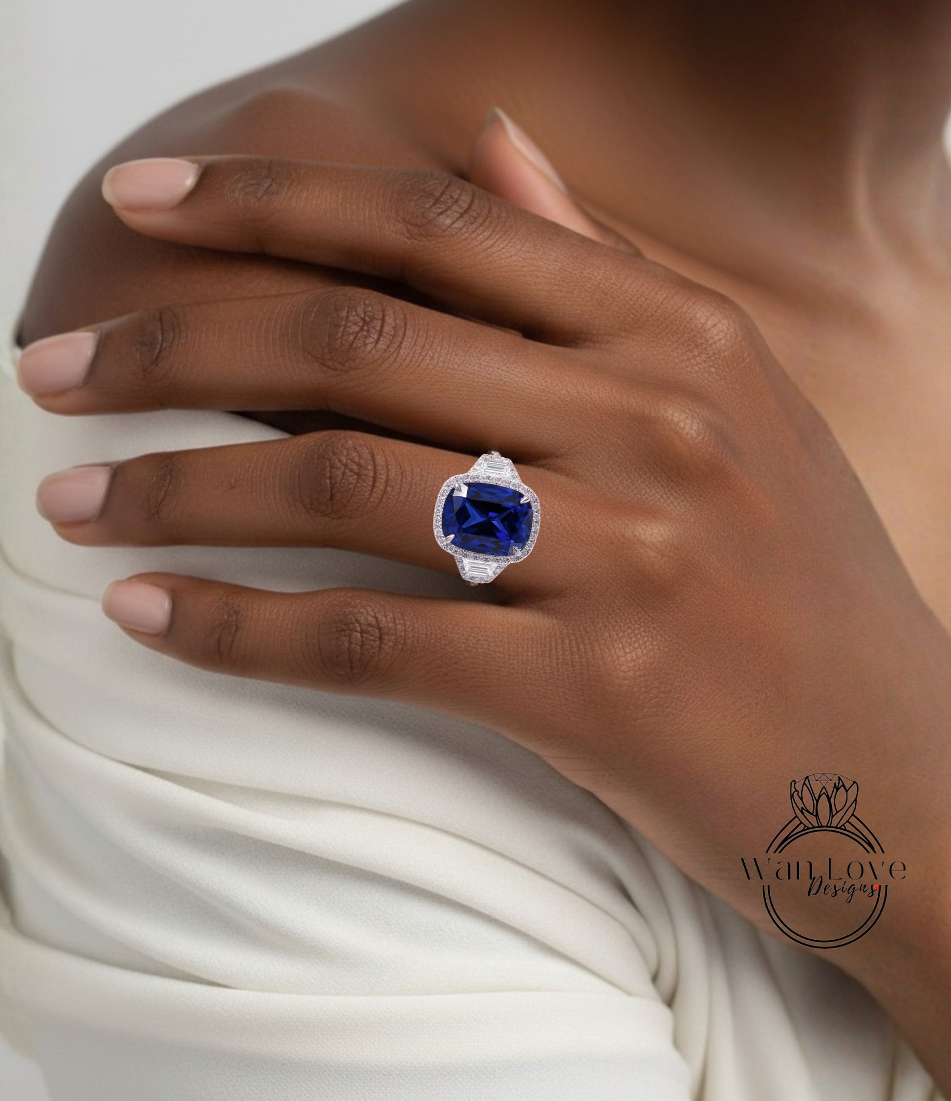 A close-up of a person's hand wearing a large, blue gemstone ring on the ring finger.