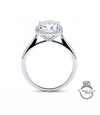 A silver engagement ring with a large, round diamond set in the center, surrounded by a halo of smaller diamonds.