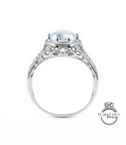 A silver engagement ring with a large, clear gemstone set in the center.