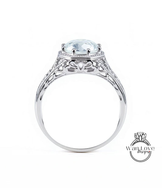 A silver engagement ring with a large, clear gemstone set in the center.