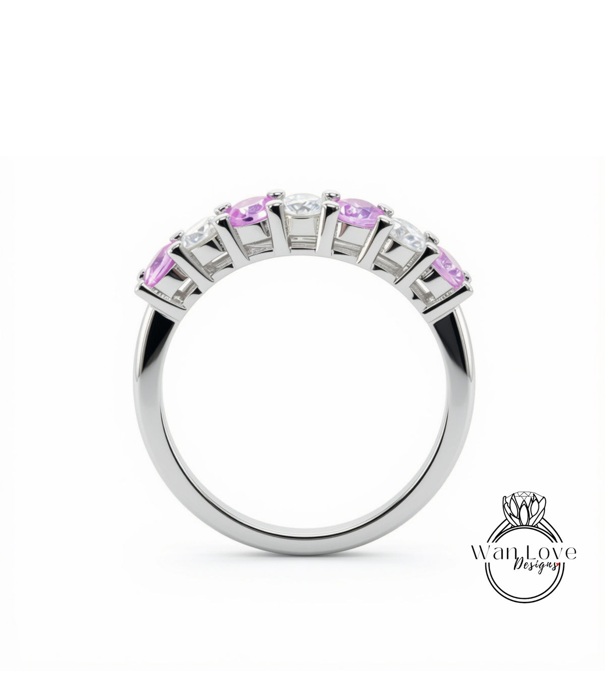 A silver ring with a row of pink gemstones, including diamonds, set in a band.