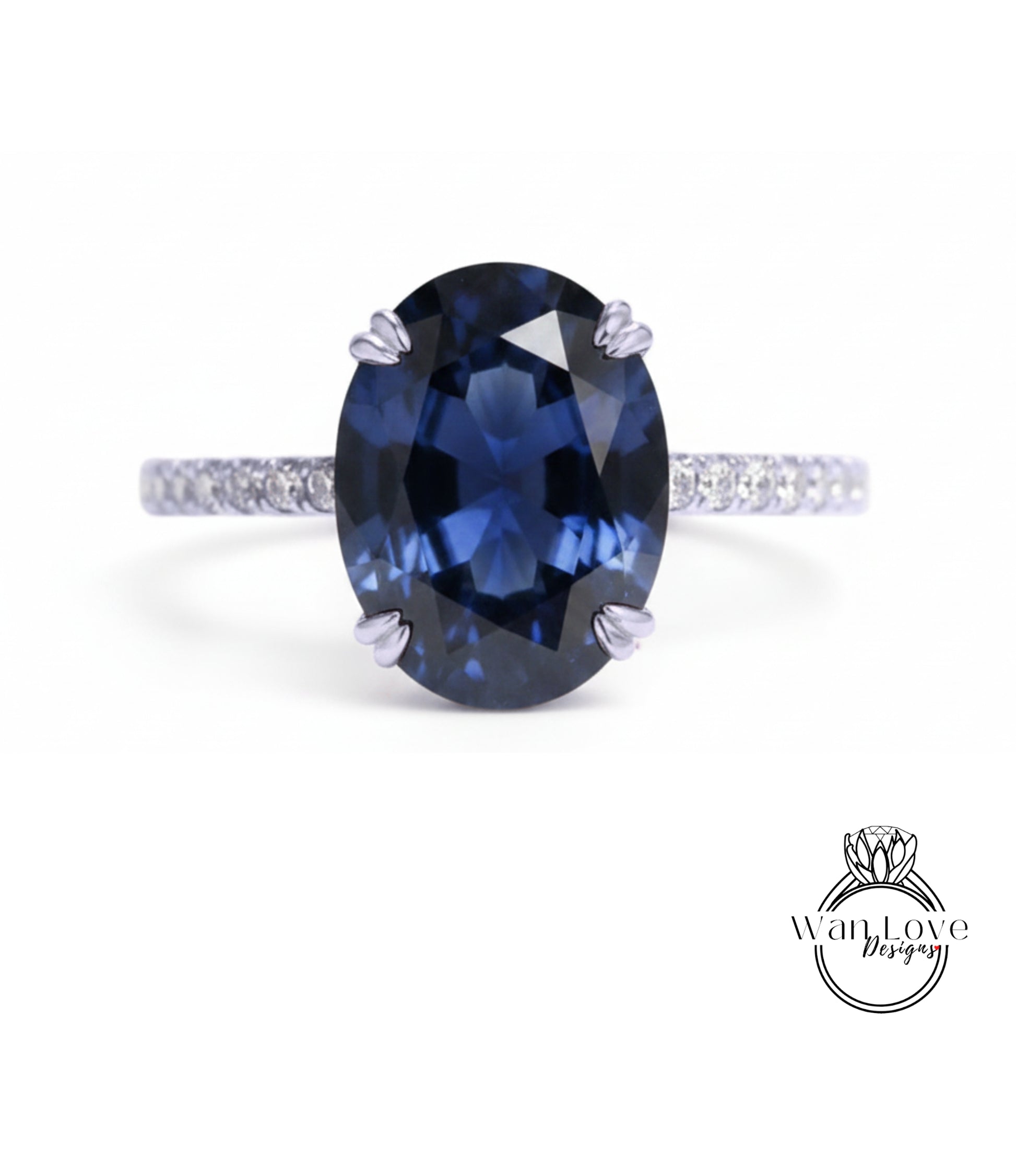 A close-up of a blue sapphire engagement ring with a diamond band.