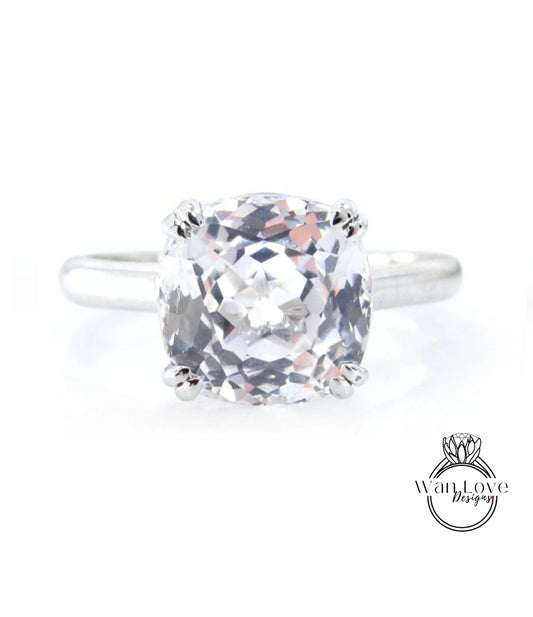 A close-up view of a diamond engagement ring with a large, clear gemstone set in a silver band.