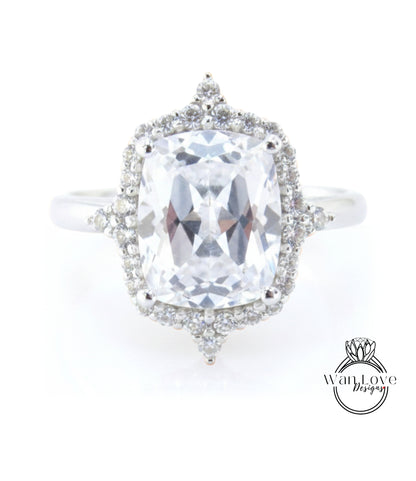 A large, clear gemstone ring with a halo of smaller diamonds around the center stone.