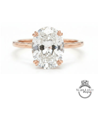 A close-up of a rose gold ring with a large oval-shaped diamond set in the center.