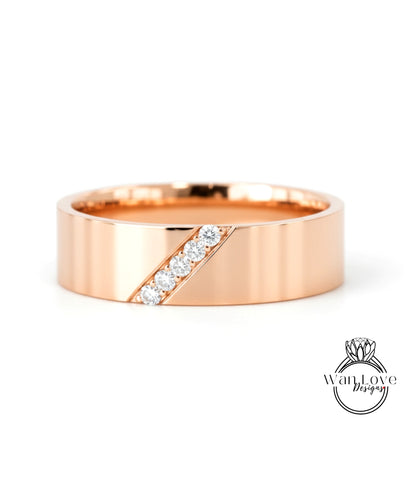 A rose gold band with a diagonal line and a diamond set in the center.