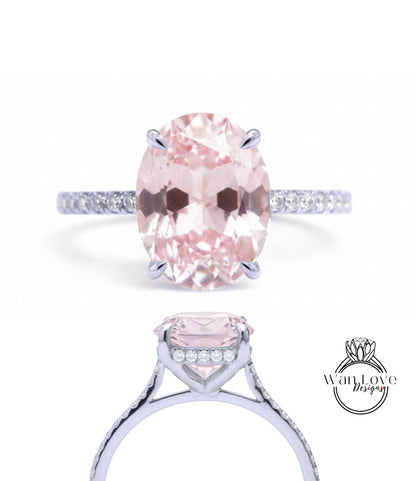 A close-up view of a diamond engagement ring with a large oval-shaped pink gemstone set in a silver band.