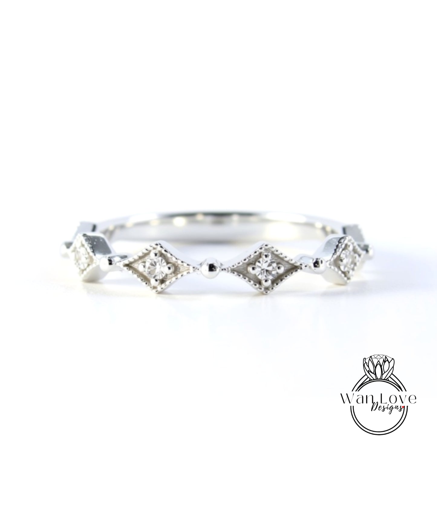 A silver ring with a row of diamond-shaped stones set in a decorative pattern.