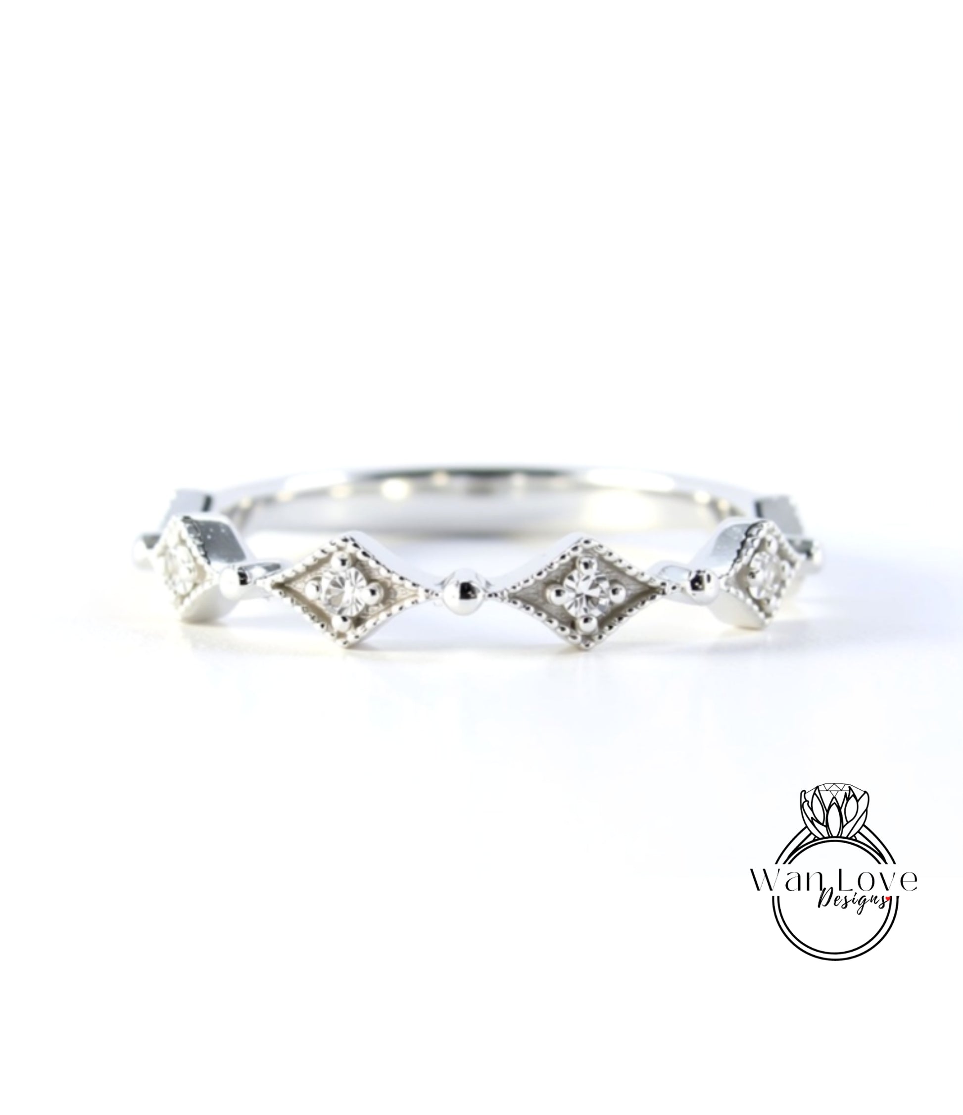 A silver ring with a row of diamond-shaped stones set in a decorative pattern.