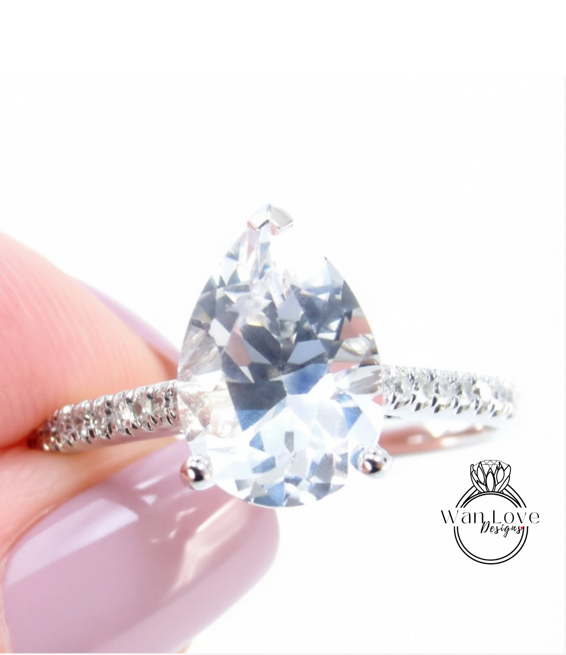 A close-up of a person's hand holding a diamond engagement ring with a large, clear gemstone.