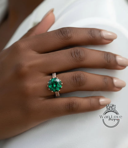 A close-up of a hand wearing a large, green gemstone ring on the ring finger.