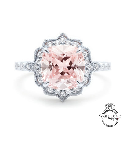 A stunning pink gemstone engagement ring with a halo of smaller diamonds around the center stone.