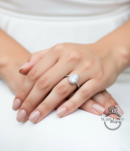A close-up of a person's hands wearing a diamond ring on the ring finger.