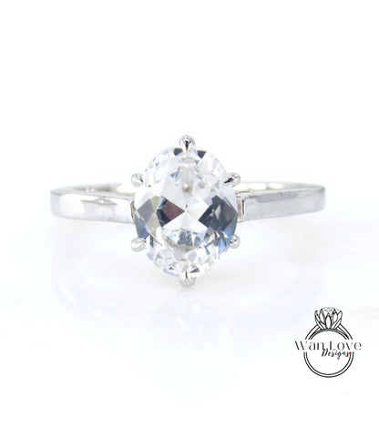 A close-up view of a diamond engagement ring with a large, clear gemstone set in a silver band.