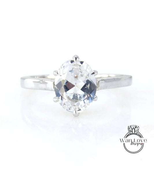 A close-up view of a diamond engagement ring with a large, clear gemstone set in a silver band.