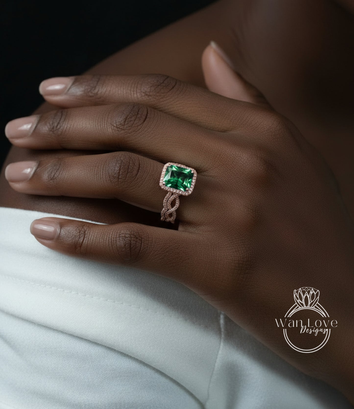 A close-up of a person's hand wearing a ring with a large, green gemstone.