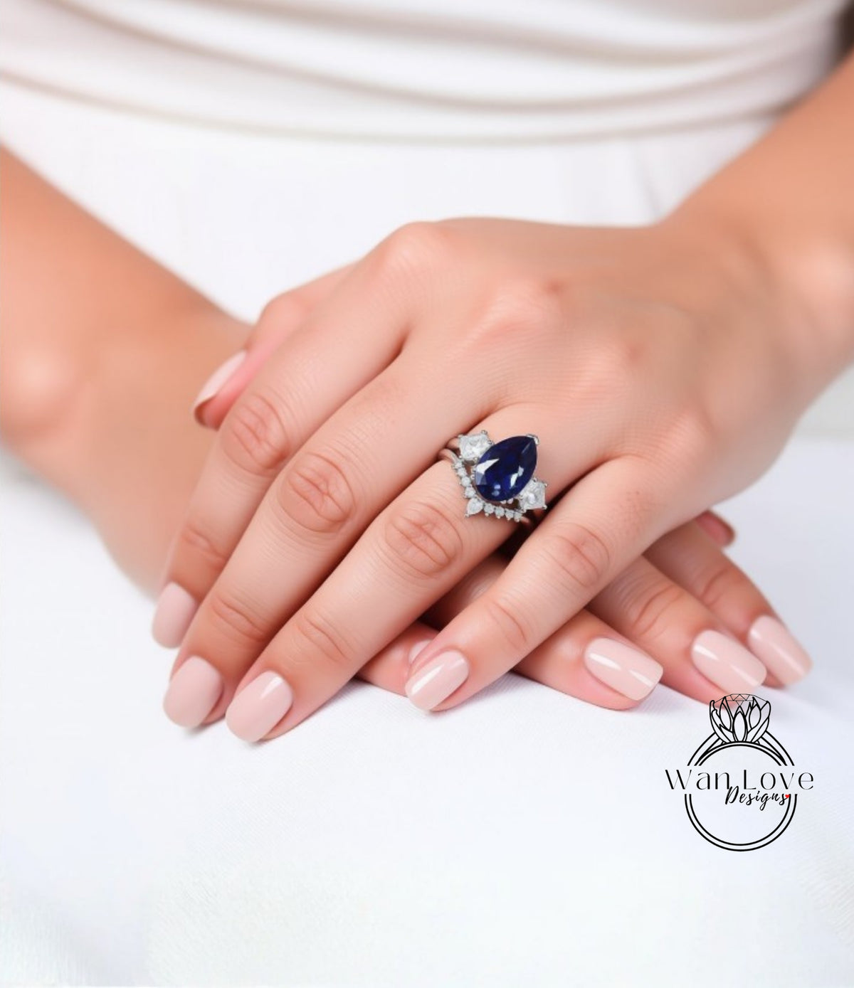 A close-up of a person's hands wearing a ring with a blue gemstone.