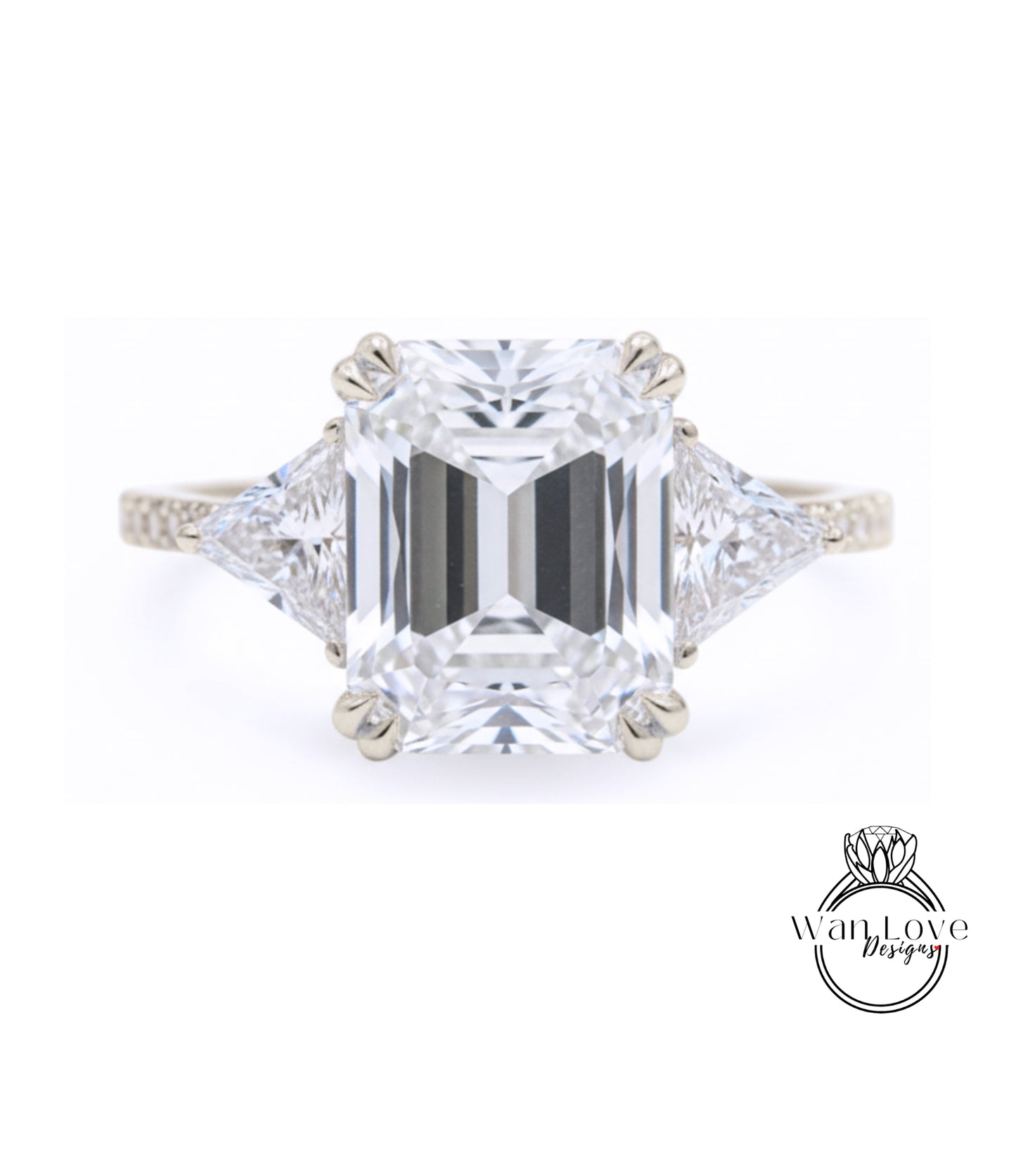 A large, clear diamond engagement ring with a prominent central diamond surrounded by smaller diamonds on either side.