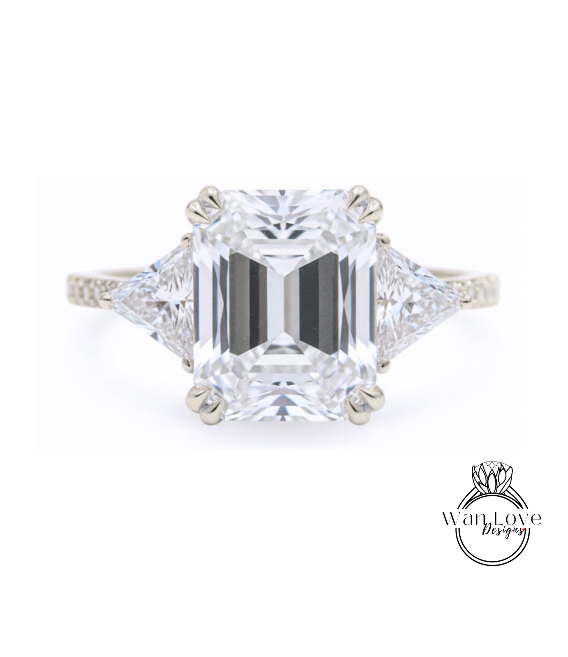 A large, clear diamond engagement ring with a prominent central diamond surrounded by smaller diamonds on either side.