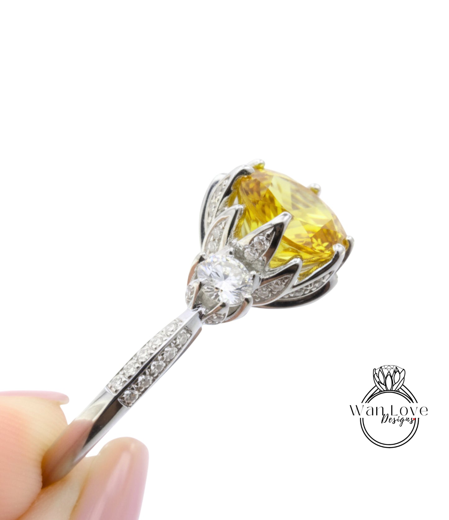 A close-up view of a diamond engagement ring with a large yellow gemstone set in a silver band.