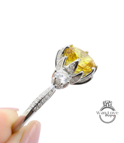 A close-up view of a diamond engagement ring with a large yellow gemstone set in a silver band.