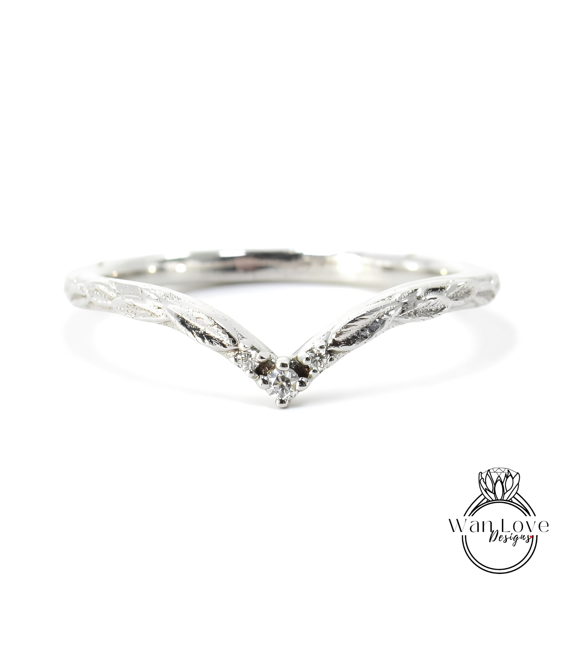 A silver ring with a v-shaped design and a small diamond in the center.
