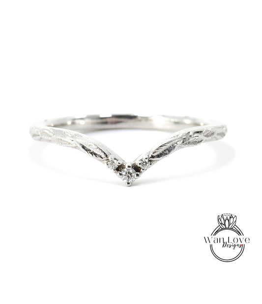 A silver ring with a v-shaped design and a small diamond in the center.