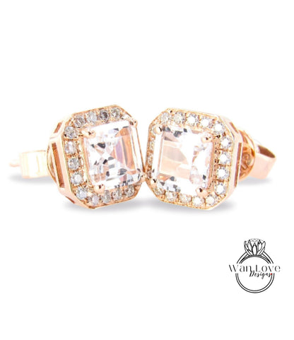 A pair of elegant gold earrings with large, clear gemstones set in a halo-like design.