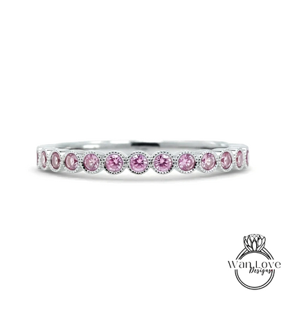 A silver band ring with a row of pink gemstones, likely diamonds, set in a row.