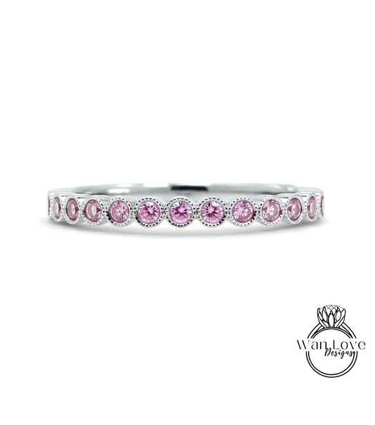A silver band ring with a row of pink gemstones, likely diamonds, set in a row.