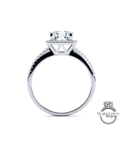 A silver engagement ring with a large central diamond and a halo of smaller diamonds around the top.