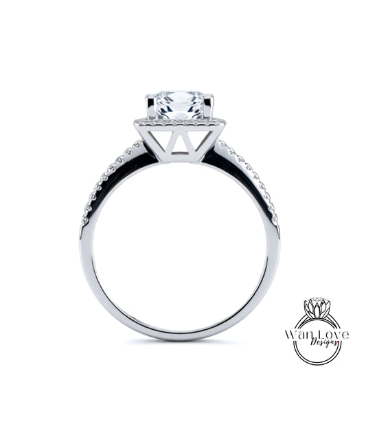 A silver engagement ring with a large central diamond and a halo of smaller diamonds around the top.