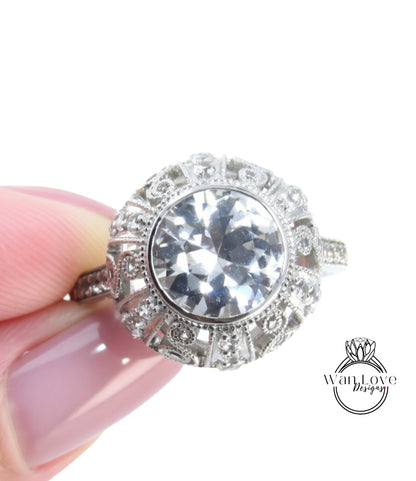 A close-up image of a person's hand holding a diamond ring with a large, clear gemstone.
