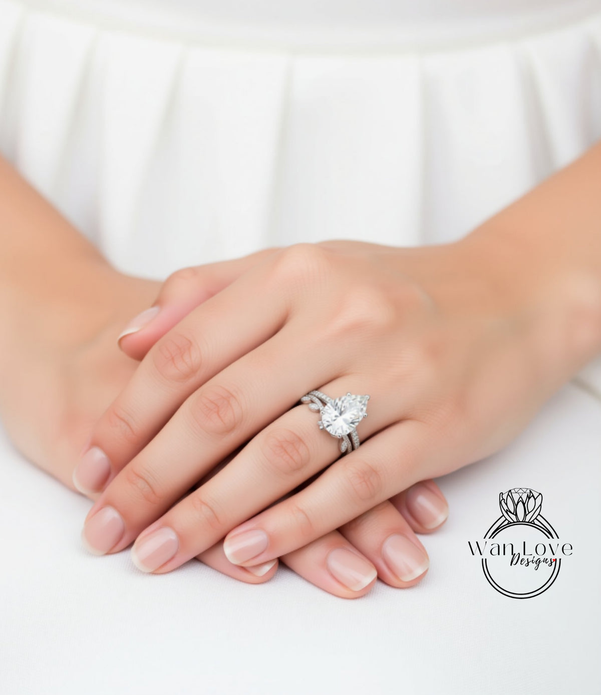 A close-up of a person's hands wearing a diamond engagement ring.
