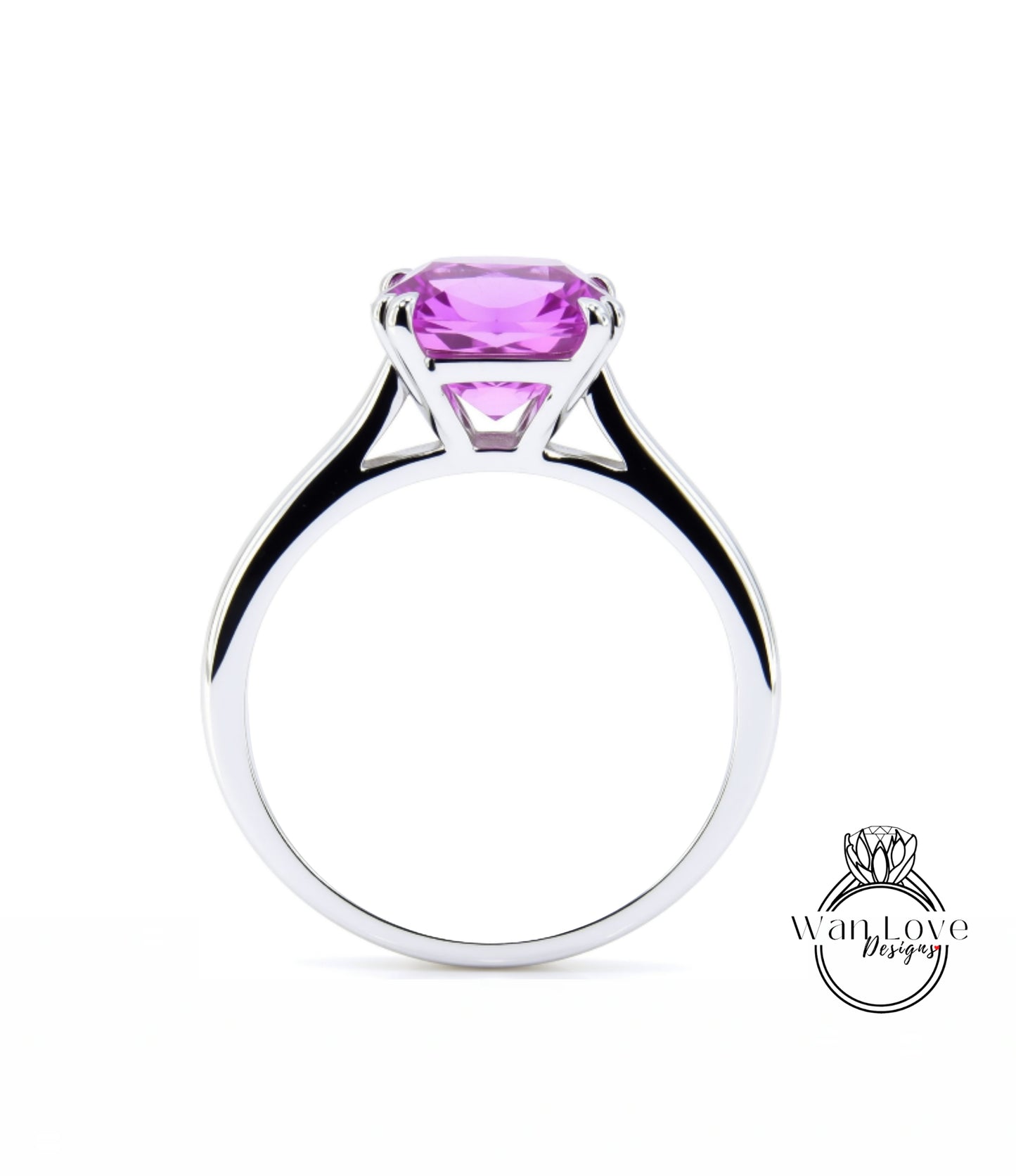 A silver ring with a large, vibrant pink gemstone set in the center.