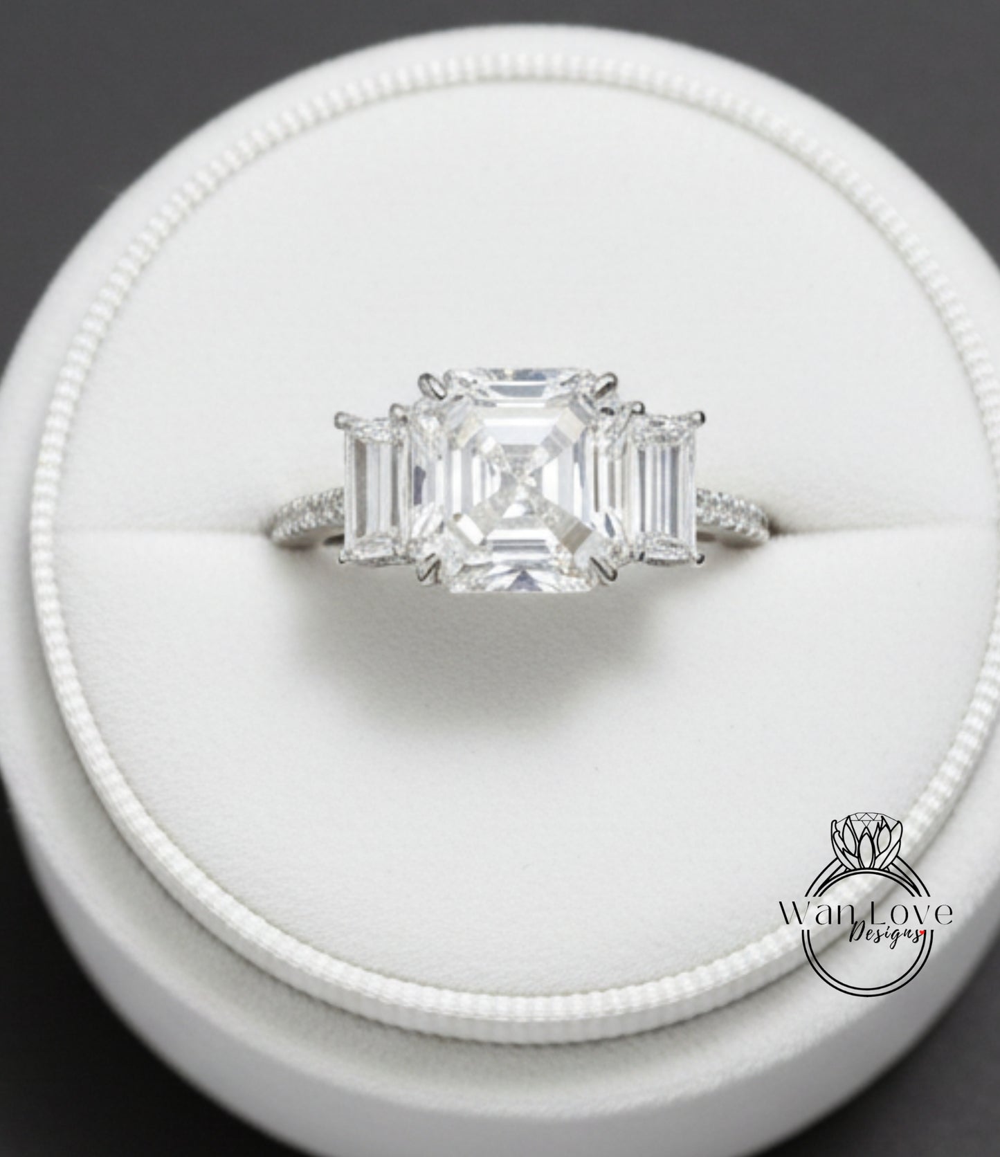 A close-up view of a diamond engagement ring displayed in a white jewelry box.