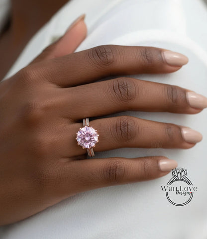 A close-up of a hand wearing a pink diamond engagement ring.