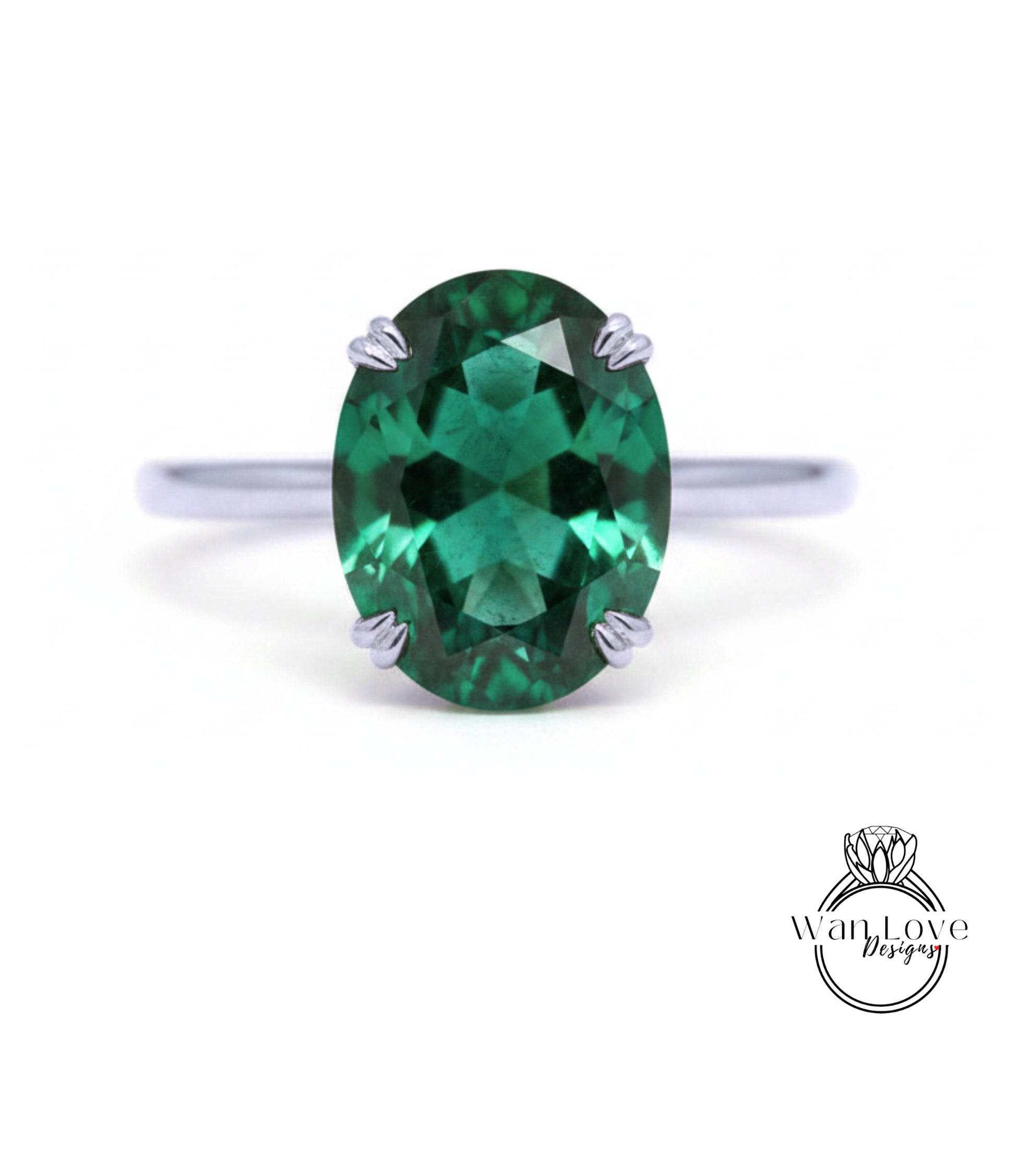 A close-up image of a silver ring with a large oval-shaped green gemstone, which appears to be a sapphire.