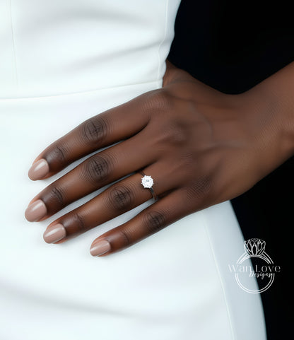 A close-up of a hand wearing a diamond engagement ring.
