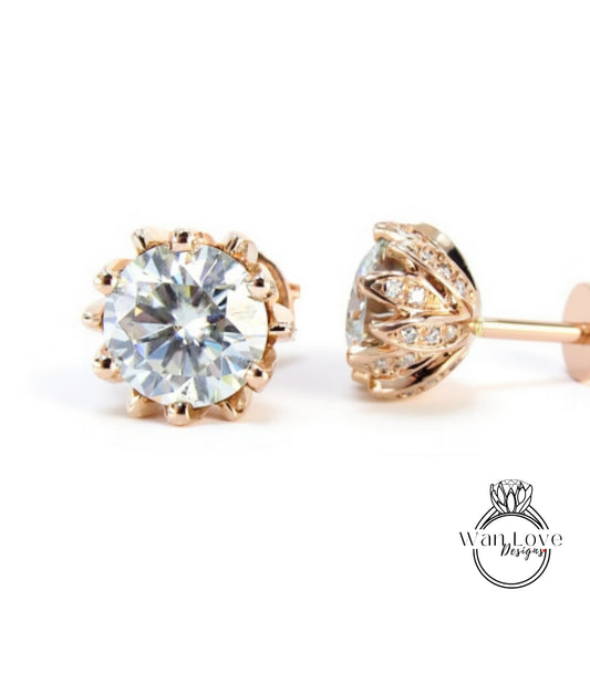 A pair of elegant gold earrings with a large, brilliant-cut diamond at the center, surrounded by a delicate floral design.