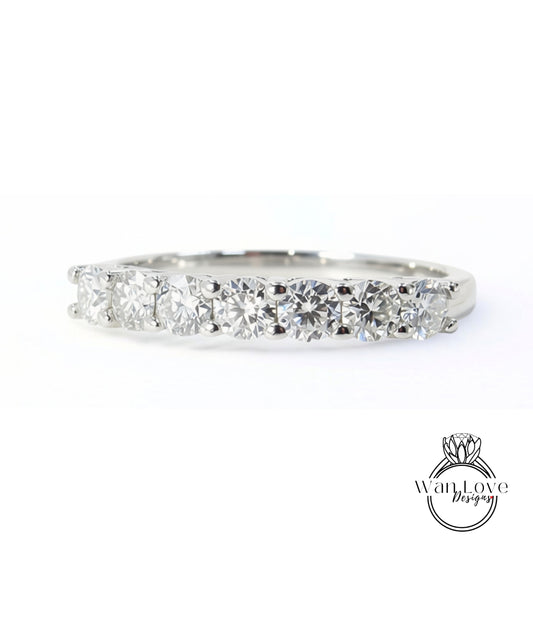 A silver ring with a row of large, clear diamonds set in a band.