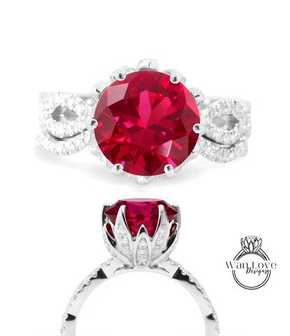 a stunning red gemstone ring with a large, round-cut gemstone set in a silver band adorned with small diamonds.