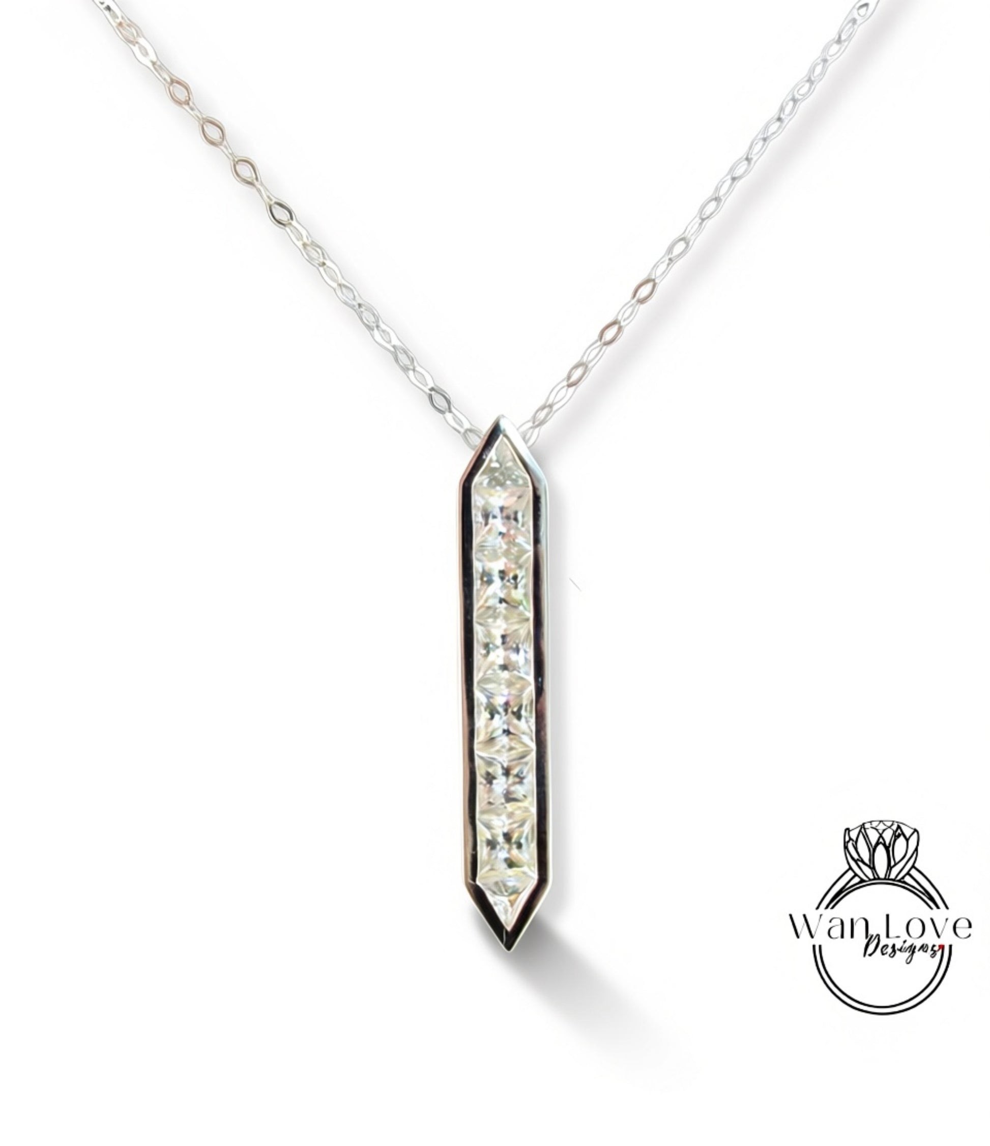 A silver necklace with a pendant featuring a row of clear gemstones.
