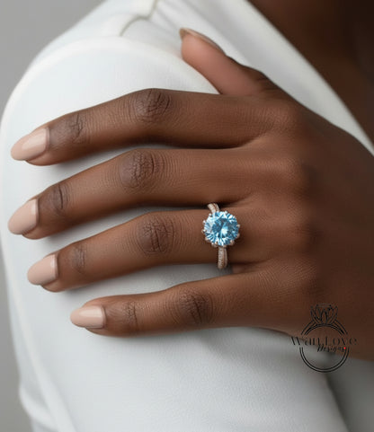 A close-up of a person's hand wearing a ring with a large blue gemstone.